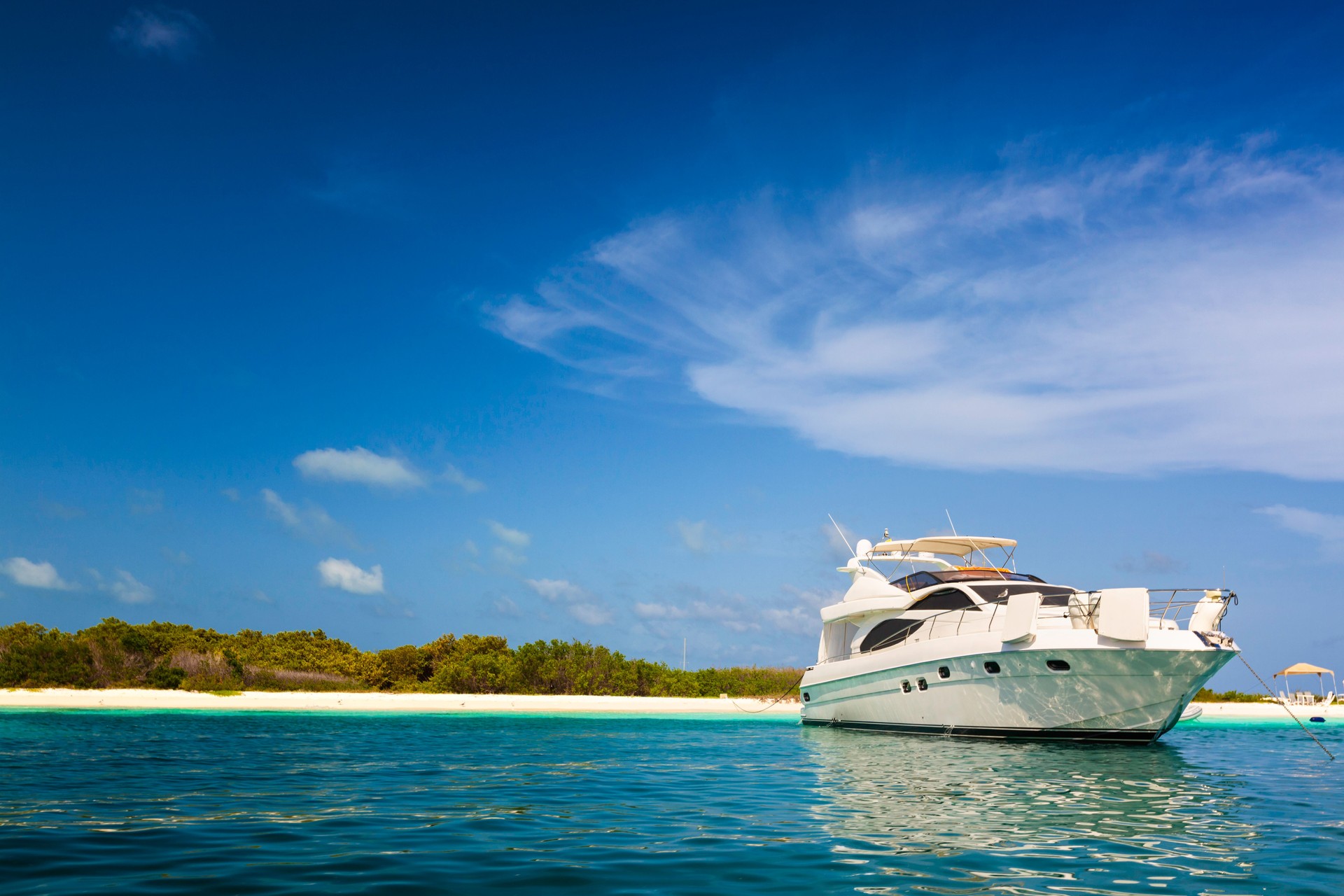 Luxury yacht anchored in a tropical island beach